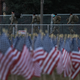 National Guard members walk past American flags placed in the ground on the National Mall as the U.S Capitol Building is prepared for the inaugural ceremonies for President-elect Joe Biden on January 18, 2021 in Washington, DC. The approximately 191,500 U.S. flags will cover part of the National Mall and will represent the American people who are unable to travel to Washington, DC for the inauguration.